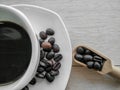 Black coffee in a white ceramic mug and coffee beans in a dish on a wooden floor Royalty Free Stock Photo